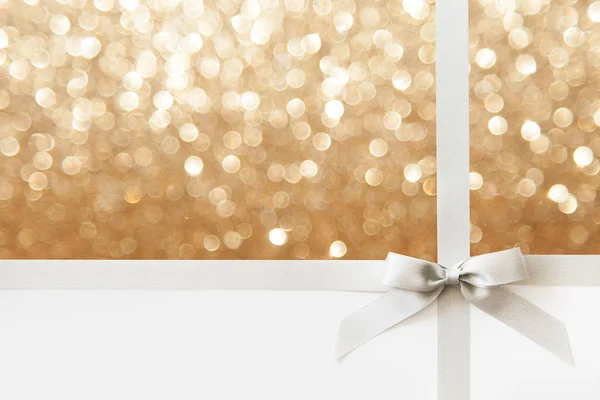 银丝带与蝴蝶结作为礼物在白色和金色闪亮的百家乐 — 图库照片
