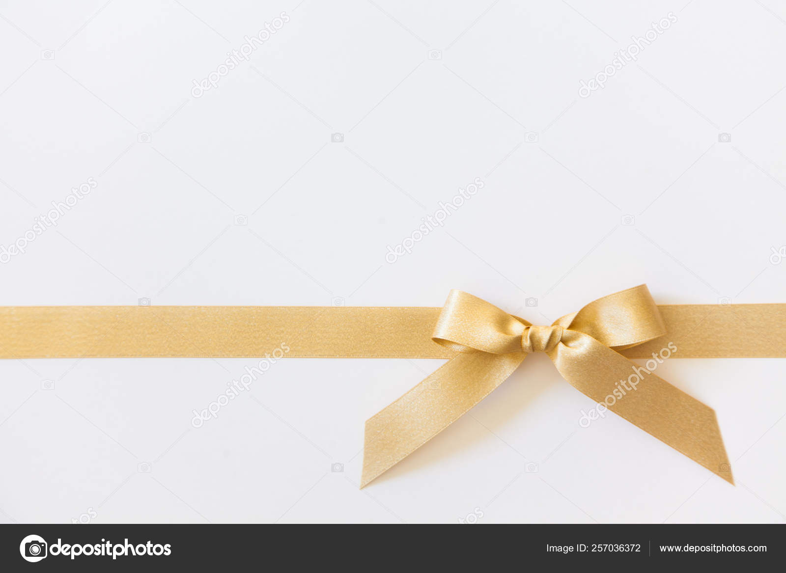 Gold ribbon with a bow as a gift on a white background Stock Photo by  ©dalivl@yandex.ru 257036372