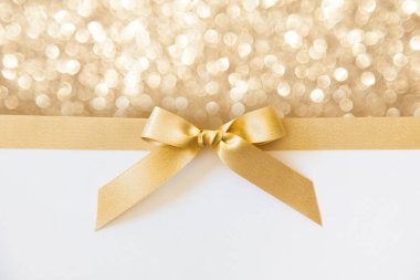 Beyaz ve altın parlak backg bir hediye olarak bir yay ile Altın kurdele