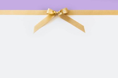 Beyaz ve menekşe backgroun bir hediye olarak bir yay ile Altın kurdele