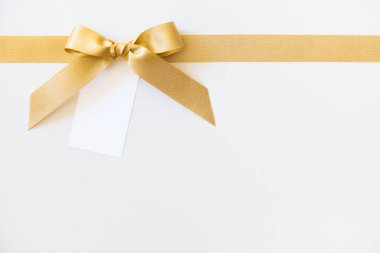 Beyaz arka planda hediye olarak bir yay ile Altın kurdele