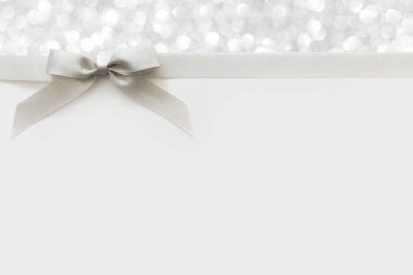 Beyaz ve parlak bir backgrou bir hediye olarak bir yay ile Gümüş kurdele