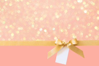 Pembe parlak arka plan üzerinde bir hediye olarak bir yay ile Altın kurdele