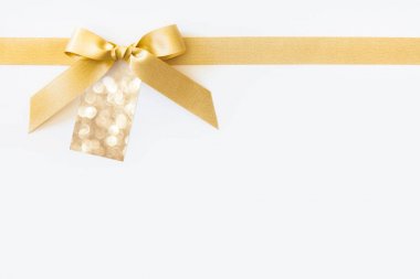 Beyaz bir arka plan üzerinde bir hediye olarak bir yay ile altın kurdele. Boş pa