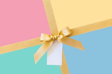 Pastel renkler arka planda hediye olarak bir yay ile Altın kurdele