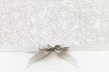 Beyaz ve parlak bir backgrou bir hediye olarak bir yay ile Gümüş kurdele
