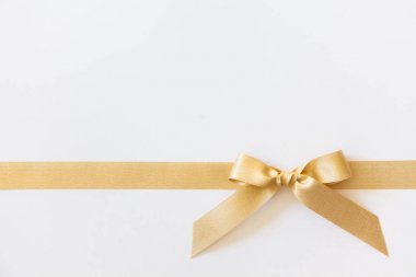Beyaz arka planda hediye olarak bir yay ile Altın kurdele