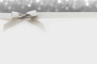 Beyaz ve parlak bir backgrou bir hediye olarak bir yay ile Gümüş kurdele