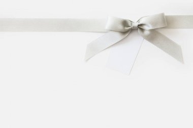 Beyaz arka plan üzerinde bir hediye olarak bir yay ile Gümüş kurdele
