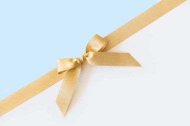 Beyaz ve mavi arka planda hediye olarak bir yay ile Altın kurdele