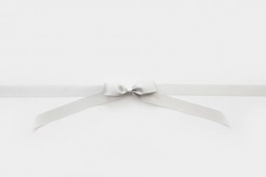 Beyaz arka plan üzerinde bir hediye olarak bir yay ile Gümüş kurdele