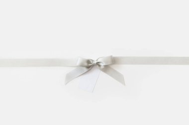 Beyaz ve parlak bir backgrou bir hediye olarak bir yay ile Gümüş kurdele