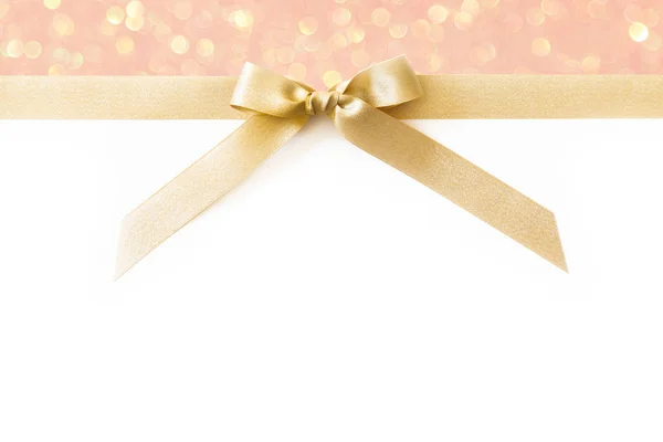 Cinta de oro con un lazo como regalo en un respaldo brillante blanco y rosa — Foto de Stock