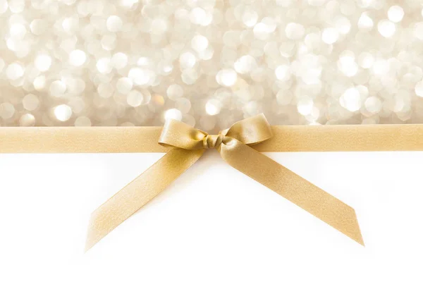 Cinta dorada con lazo como regalo sobre fondo blanco y brillante — Foto de Stock