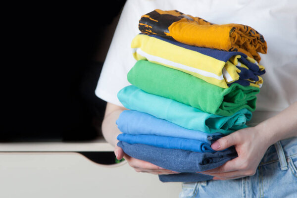 Женщина складывает одежду вертикально на полке шкафа. Японский язык
