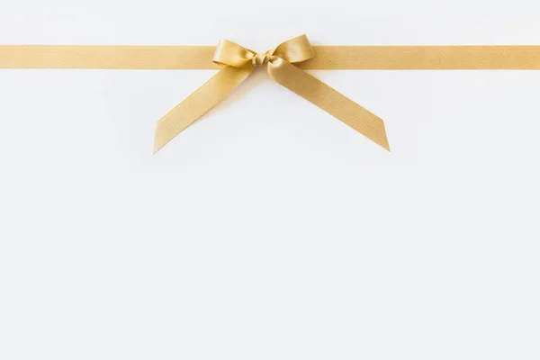 Gold ribbon with a bow as a gift on a white background — Stock Photo, Image