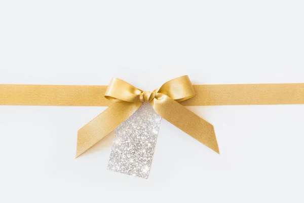 Beyaz bir arka plan üzerinde bir hediye olarak bir yay ile altın kurdele. Boş pa — Stok fotoğraf