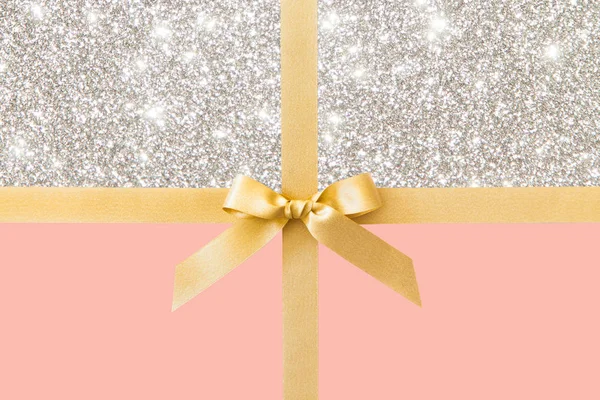 金丝带与蝴蝶结作为礼物在粉红色和银色闪亮背部 — 图库照片