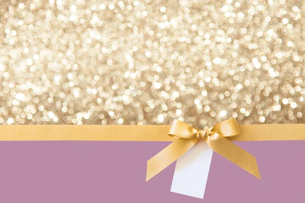 Cinta de oro con un lazo como regalo en un bac brillante violeta y oro — Foto de Stock