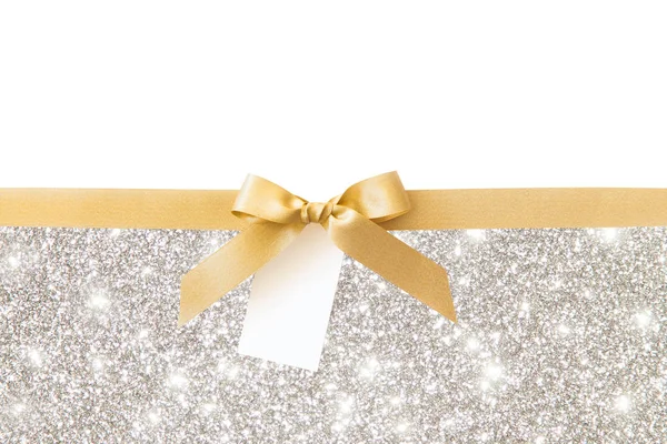Gümüş parlak arka plan üzerinde bir hediye olarak bir yay ile Altın kurdele — Stok fotoğraf