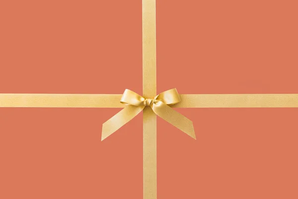 Kırmızı arka plan üzerinde bir hediye olarak bir yay ile Altın kurdele — Stok fotoğraf