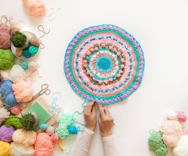 Kadın elleri beyaz bir üzerinde, renk yün ile yuvarlak mandala örgü 