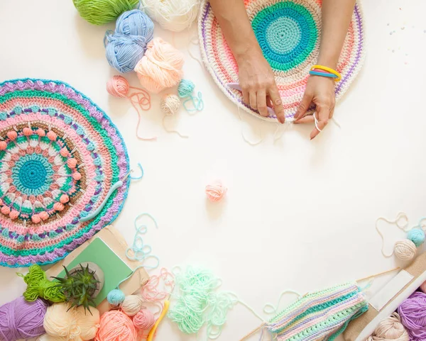 Mãos femininas que unem mandala redonda com lã a cores, em um branco — Fotografia de Stock