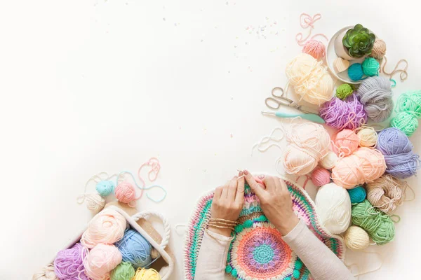 Mani femminili che lavorano a maglia mandala rotondo con lana a colori, su un bianco — Foto Stock