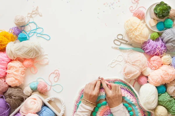 Mains féminines tricot mandala rond avec de la laine de couleur, sur un blanc — Photo