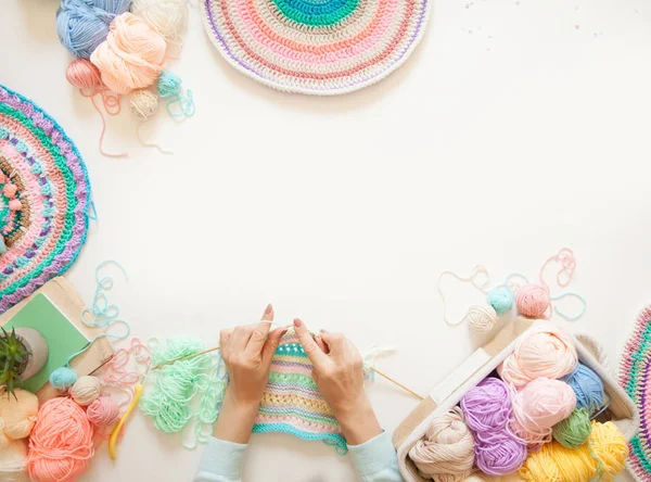 Mãos femininas que unem mandala redonda com lã a cores, em um branco — Fotografia de Stock