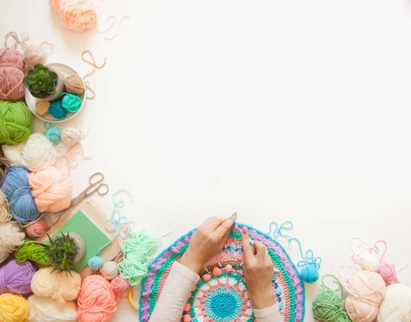 Mãos femininas que unem mandala redonda com lã a cores, em um branco — Fotografia de Stock