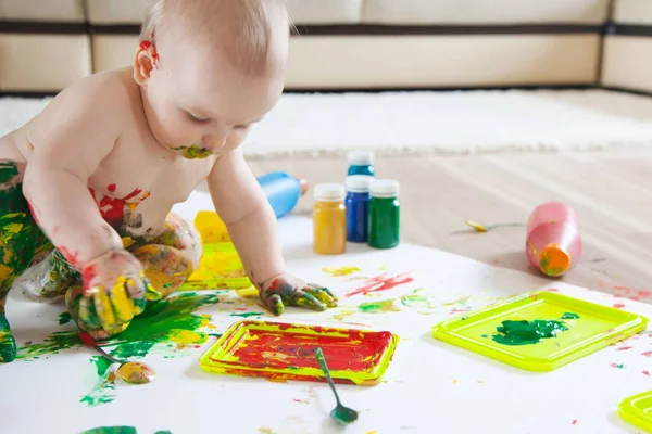 Bébé enfant dessine avec des peintures colorées mains, pieds sales. Blanc li — Photo