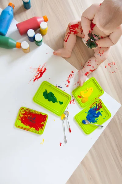 Bébé enfant dessine avec des peintures colorées mains, pieds sales. Blanc li — Photo