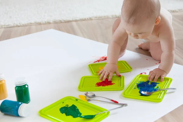Bebé niño dibuja con pinturas de colores manos, pies sucios. Blanco li — Foto de Stock