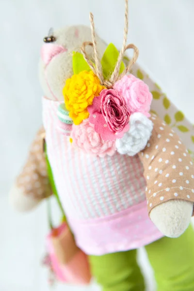 Handmade toy. Doll of textiles, fabrics and yarn. Rabbit with fl