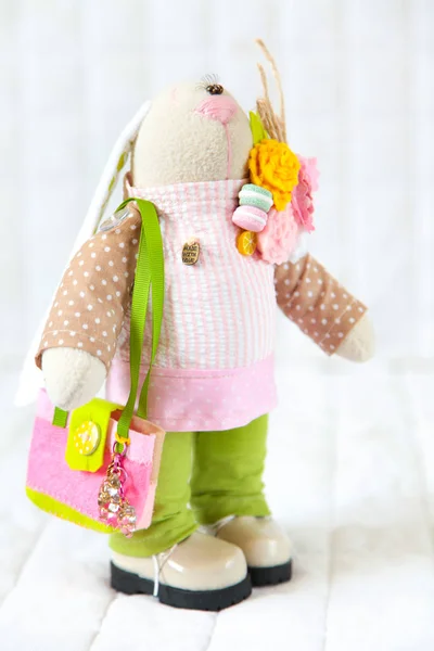 Handmade toy. Doll of textiles, fabrics and yarn. Rabbit with fl