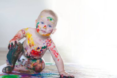 Bebek çocuk renkli boyalar eller, kirli ayaklar ve finge ile çizer