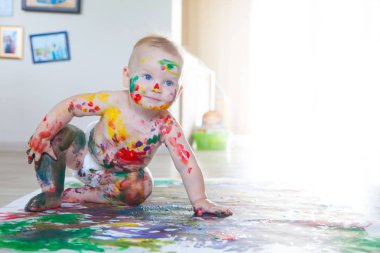 Bebek çocuk renkli boyalar eller, kirli ayaklar ve finge ile çizer