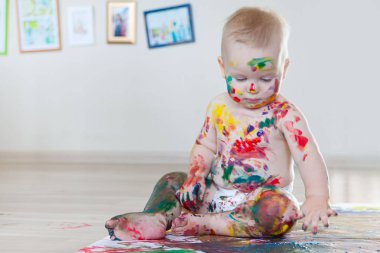 Bebek çocuk renkli boyalar eller, kirli ayaklar ve finge ile çizer