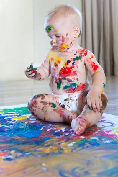 Bébé enfant dessine avec des peintures colorées mains, pieds sales et finge — Photo