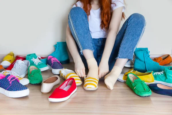 Wiele kolorowych butów damskich na podłodze. Kobieta wybiera ją — Zdjęcie stockowe