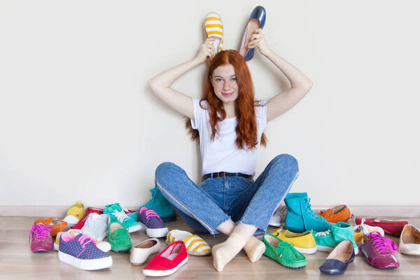 Girl chooses shoes in room on beige background