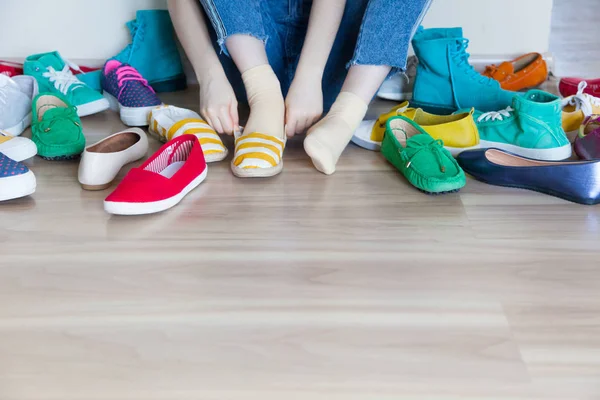 Menina escolhe sapatos no quarto no fundo bege — Fotografia de Stock