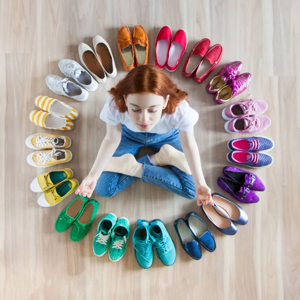 Yerde bir sürü renkli kadın ayakkabısı var. Bir kadın onu seçer.