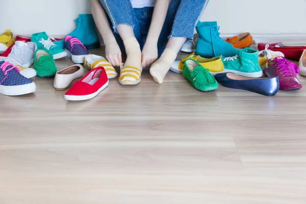 Yerde bir sürü renkli kadın ayakkabısı var. Bir kadın onu seçer.