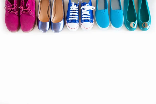 Olika färg ljusa kvinnliga ungdoms skor på en vit bakgrund. — Stockfoto