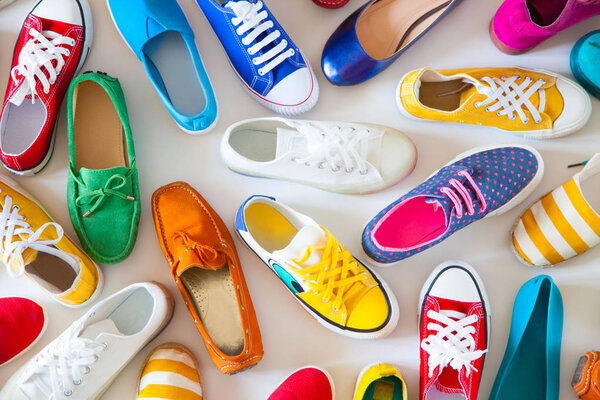 Various color bright female youth shoes on a white background.