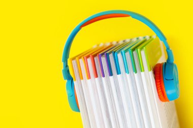 Renkli kulaklıklar ve renkli arka plan kitapları. Au kavramı