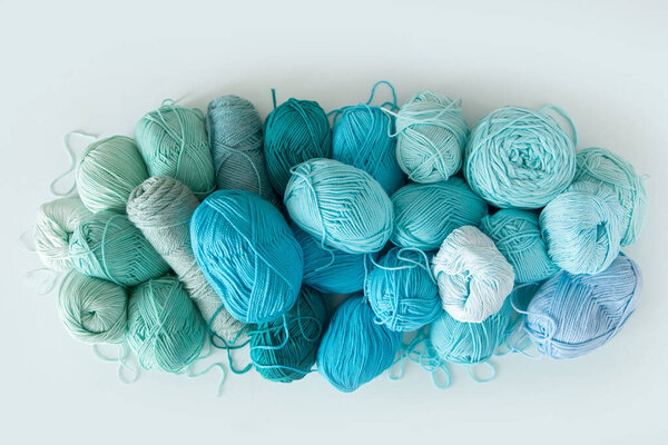 Colored balls and skiens of yarn. Top view. Aquamarine colors. Y