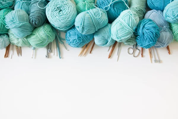 Yarn of green, turquoise, aquamarine and blue colors. White wood — Stock Photo, Image